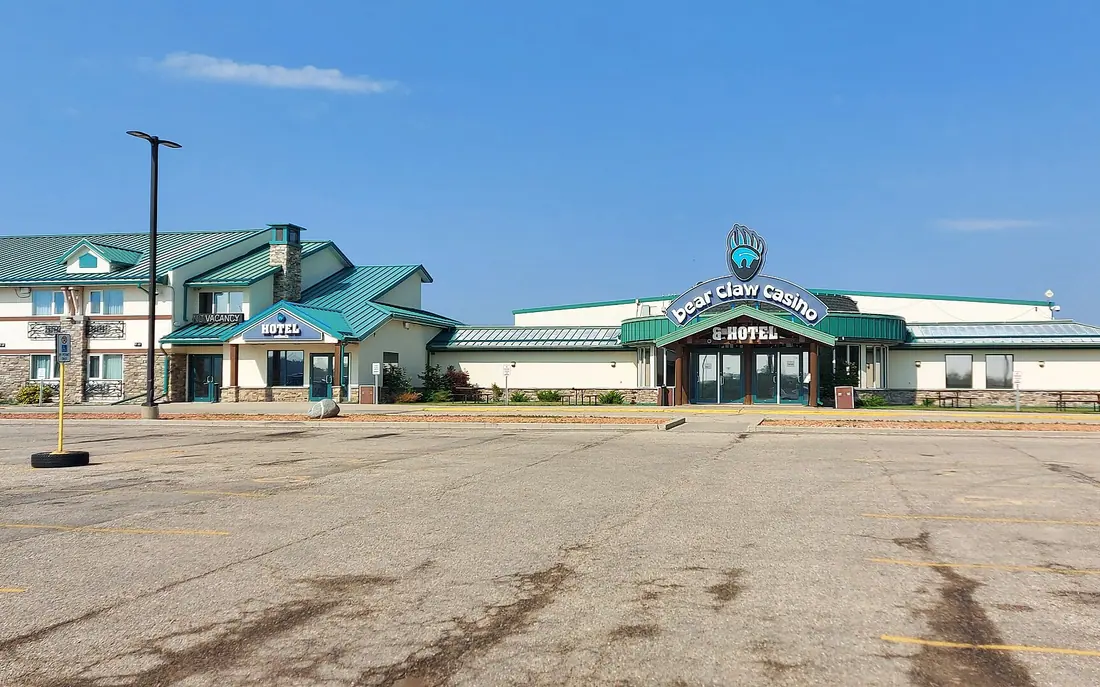 Bear Claw Casino and its hotel wing with green roofs on White Bear First Nations, seen across the empty parking lot
